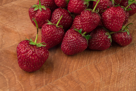 一堆美味多汁的红草莓，放在木板上，特写，