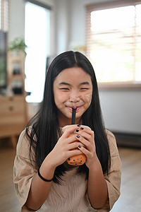 微笑的亚洲女孩喝冰泡奶茶。