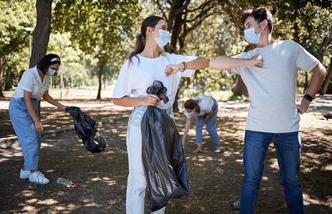 回收、志愿者和负责任的积极分子，负责新冠清洁社区公园，同时用肘部碰撞迎接团队合作。