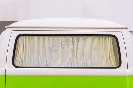 明亮的白色和绿色旅行车的窗帘窗