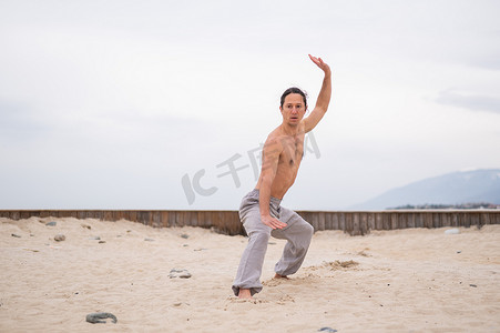 健身气功摄影照片_长头发的白人男子在户外练习气功。