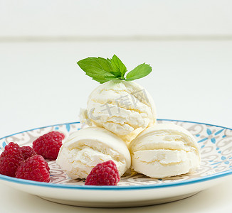 白色冰淇淋球摄影照片_圆盘中的香草冰淇淋球和红树莓