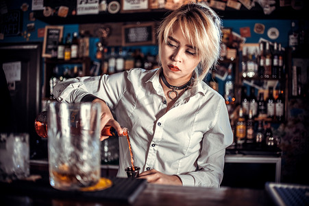 周度摄影照片_专注的女调酒师在吧台调制鸡尾酒