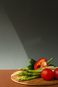木板上放着蔬菜：西红柿、芦笋、黄瓜、红甜椒。