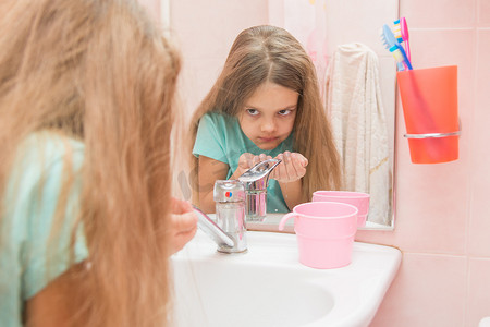 正在洗漱的女孩看着浴室里的镜子