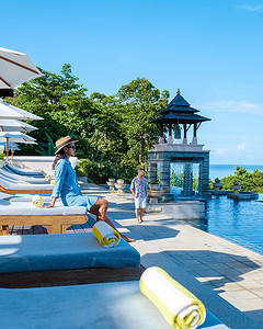 沙滩椅摄影照片_泰国兰达岛，泰国一家豪华酒店游泳池旁的豪华沙滩椅