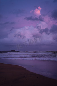 粉紫色摄影照片_加勒海滩上色彩缤纷的粉紫色日落，阳光反射在海滩海浪上。