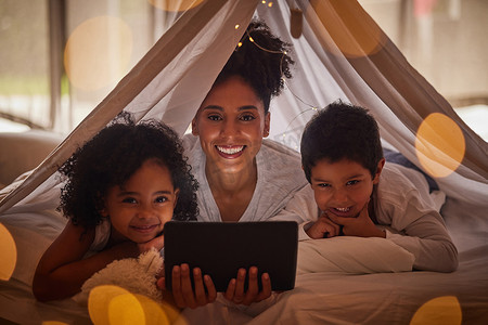 全家福、平板电脑和儿童卡通在线应用程序、流媒体和数字夜间故事在家里的毯子堡垒帐篷里。