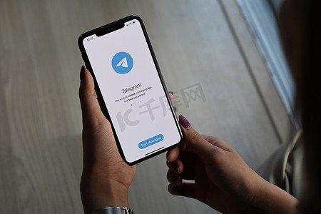 泰国清迈 — 2022年3月1日：手持 iPhone 11 Pro Max 的女性，屏幕上有 Telegram 应用程序。
