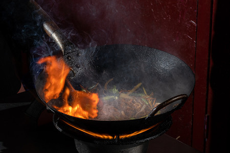 Funchoza 火焰米粉与蔬菜在炒锅中煮。