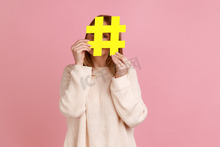 人气标签摄影照片_隐藏在黄色标签符号后面的女人，用哈希符号遮住脸，博客的概念。