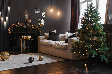 圣诞节的树摄影照片_圣诞节室内有美丽的圣诞树、沙发、灯泡和深色背景。