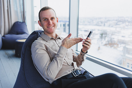 一位商人坐在现代化的办公空间中通过电话与客户沟通。
