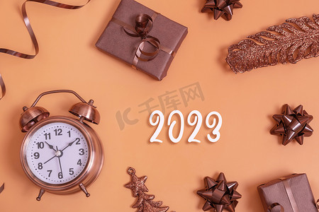 数字倒计时创意摄影照片_2023年新的亚尔数字，带有闹钟和彩色背景顶视图的礼品盒