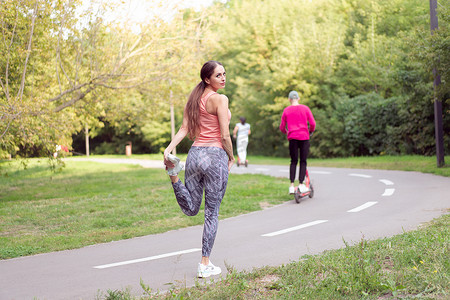 在夏季公园站在跑道上进行跑步练习之前，适合女性热腿