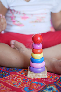 幼儿园邀请函摄影照片_孩子在床上玩婴儿玩具，儿童发展概念。