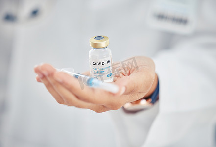 疫苗瓶摄影照片_Covid疫苗瓶、医生手和药物注射，用于医院诊所的医疗保健、健康安全和抗病毒加强注射。