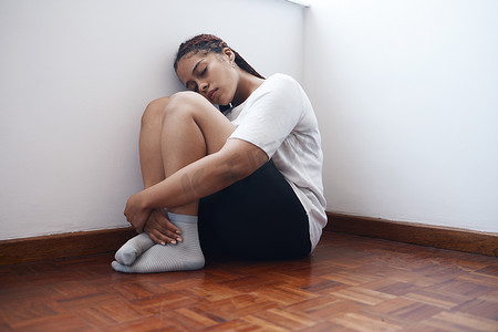 抑郁、焦虑和孤独的女人坐在角落里，患有心理健康问题或问题。