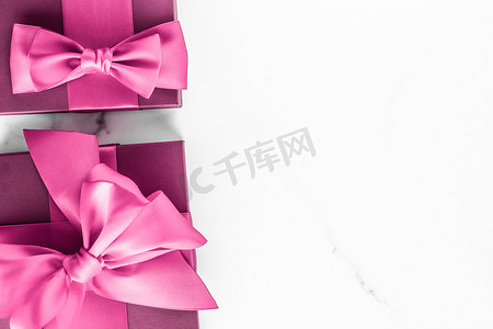 大理石背景丝绸蝴蝶结粉色礼盒、女婴送礼会礼物和豪华美容品牌的魅力时尚礼物、假日平底艺术设计