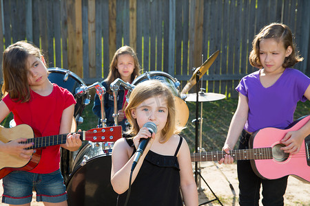 儿童歌手女孩在后院演奏现场乐队唱歌