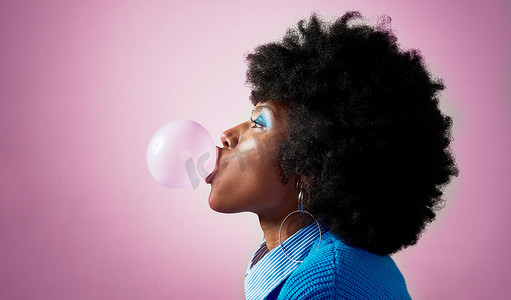 泡泡糖、非洲头发和粉红色工作室背景的黑人女性，有着时尚、酷炫或牙买加潮流的发型。