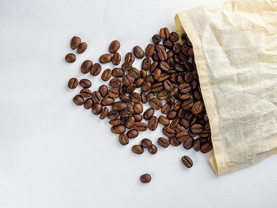 白色背景中黄麻袋中烘焙的咖啡豆