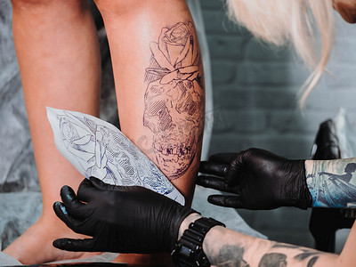 纹身师将未来纹身图画在客户的脚上