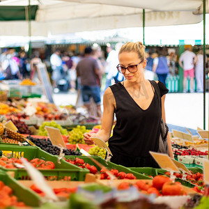 妇女在当地食品市场购买水果和蔬菜。