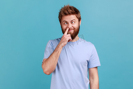 表情emoji爷摄影照片_穿着蓝色 T 恤的男人挖鼻孔，伸出舌头，表情愚蠢滑稽，到处闲逛
