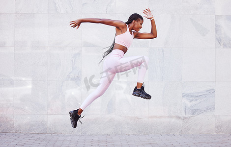 能量、运动和黑人女性在户外跳跃跑步，通过墙壁模型进行健身、健康和户外训练。