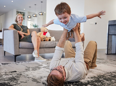 家庭直升机、儿童游戏和父亲，精力充沛地与孩子一起放松，在地板上小心翼翼地爱，在家里的客厅里一起搞笑。
