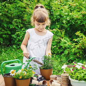 农舍摄影照片_一个小女孩正在种花。
