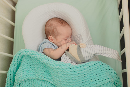婴儿房间摄影照片_婴儿正在婴儿床上睡觉。
