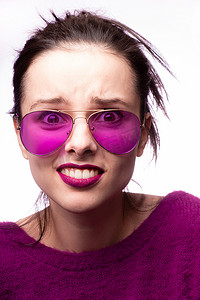 紫红色头发摄影照片_穿着紫色毛衣、紫色眼镜、嘴唇上涂着紫色口红的女人