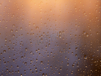 水和雨滴在玻璃上的复古色调，抽象视图，蓝色玻璃背景上的雨滴/雨后玻璃上的滴。