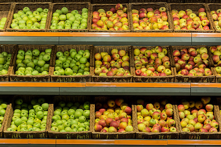 超市柜台上的货架上摆着水果彩色苹果的盒子