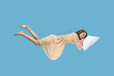女人悬浮在半空中，趴着睡，躺在舒适的枕头上