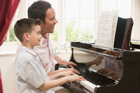 男人和小男孩弹钢琴微笑