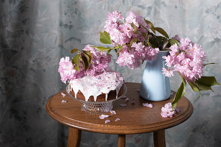 复活节蛋糕、彩绘鸡蛋和桌上的一束粉色樱花