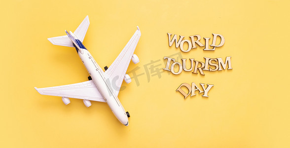 世界旅游日文字，黄色背景上的木字，飞机顶视图，平躺