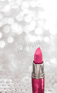 银色圣诞节、新年和情人节假日闪光背景上的粉色口红、豪华美容品牌的化妆品和化妆品