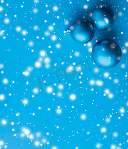 蓝色冬日雪花摄影照片_蓝色背景的圣诞小玩意，雪花闪闪发亮，豪华冬日贺卡