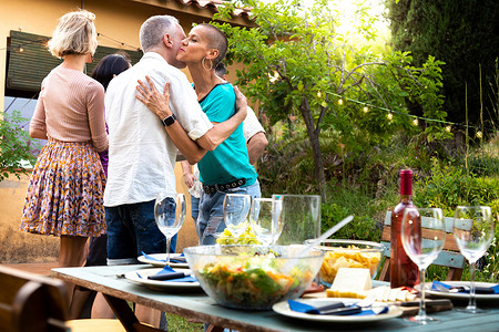 晚宴邀请函摄影照片_朋友们抵达参加花园晚宴。