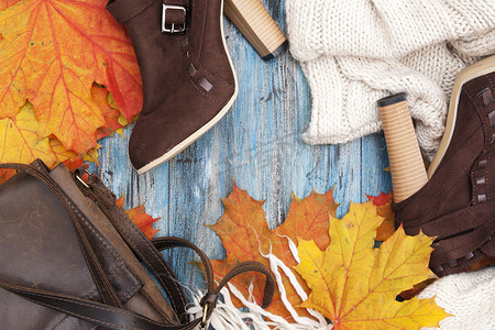 秋季平铺在蓝色复古背景上铺着女性物品和枫叶，有可用的文本空间