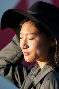 一位闭着眼睛的年轻亚洲女性的肖像