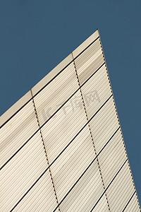 线条和矩形纹理形成在建筑白色金属墙上，背景为蓝天。