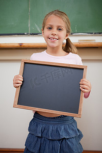 一个快乐的女孩拿着学校石板的肖像