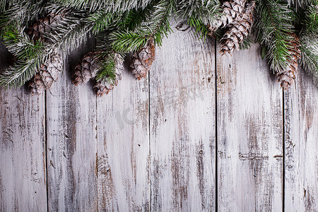 贺卡边框摄影照片_白色破旧的圣诞边框，上面覆盖着积雪的松果