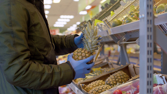 一名男子在超市挑选菠萝