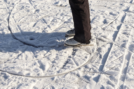 特写女人的脚穿着滑冰靴站在冰上。